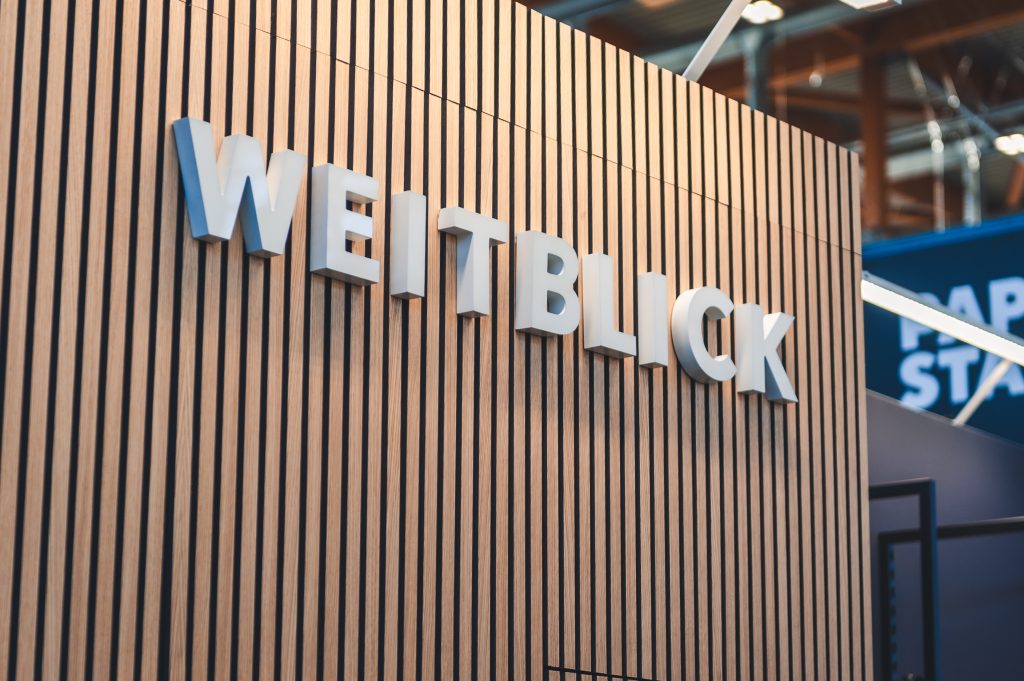 Das Weitblick Logo modern auf einer Holzwand